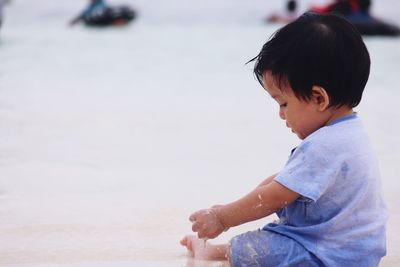 Baby boy playing with sand at beach