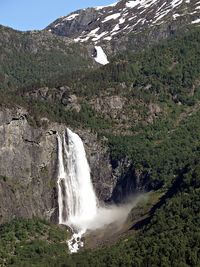 Scenic view of waterfall against sky