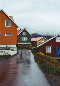 Street amidst houses and buildings against sky