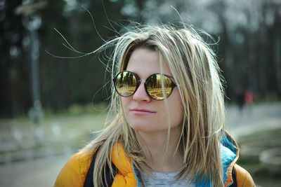 Close-up of young woman wearing sunglasses while standing outdoors