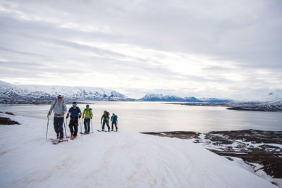 A group backcountry skiing in iceland with the ocean in the background