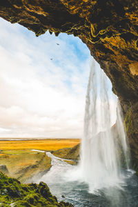 Scenic view of waterfall against sky