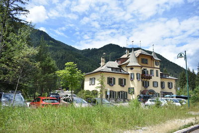 Cars on street by buildings against sky