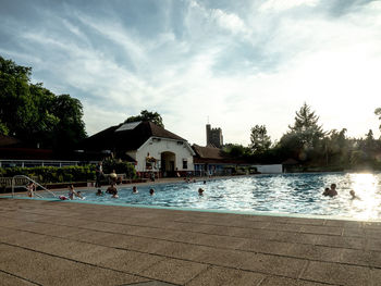 View of swimming pool by building against sky