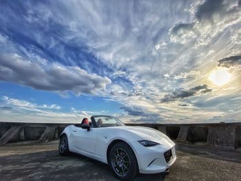 Car on road against cloudy sky