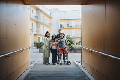 Portrait of family standing in courtyard of residential neighborhood