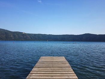 Scenic view of lake against clear blue sky