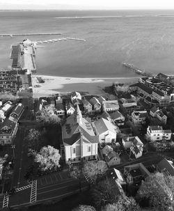 High angle view of town by sea against sky