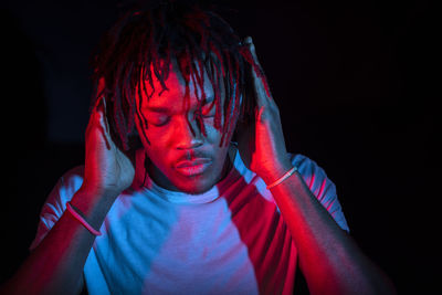 Portraits of beautiful african young man under blu and red lights