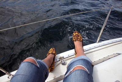 Low section of woman sitting on boat in river