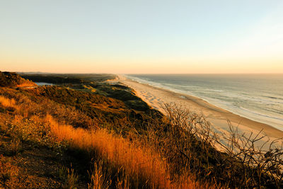 Scenic view of sea against clear sky during sunset