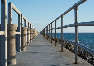 Pier over sea against clear sky