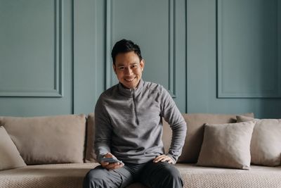 Young man sitting on sofa at home