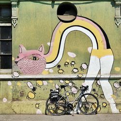 Side view of bicycle parked against wall