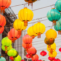 Low angle view of lanterns hanging against sky