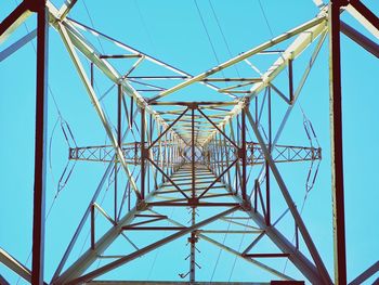 Low angle view of electricity pylon against blue sky