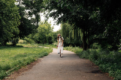 Rear view of woman walking on road