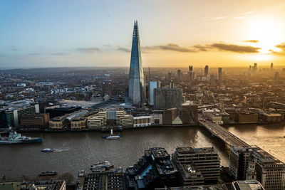 Aerial view of buildings in city during sunset