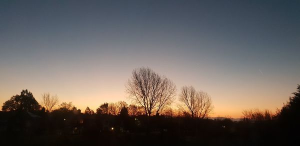 Silhouette trees against sky during sunset