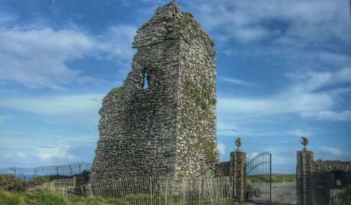 Low angle view of old building against cloudy sky