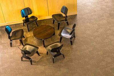 High angle view of empty chairs and table on floor
