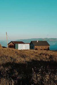 Built structure on field against clear blue sky