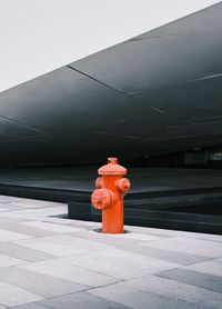 Red fire hydrant on footpath against building