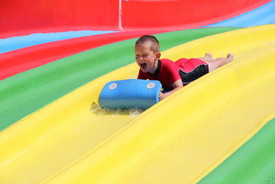 Full length of boy playing on slide at playground