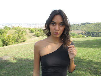Portrait of beautiful young woman standing on land