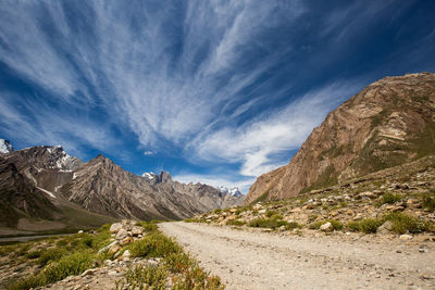 Scenic view of road by mountains against sky