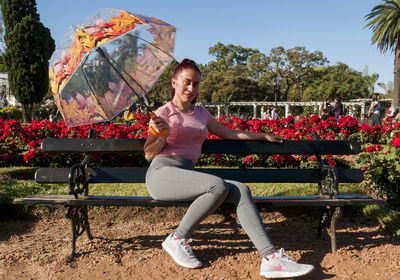 Portrait of smiling woman sitting by plants