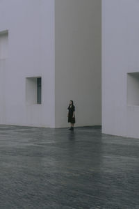 Full length of woman walking by building in city