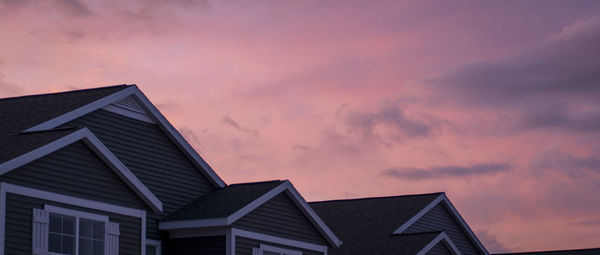 Low angle view of buildings against sky at sunset