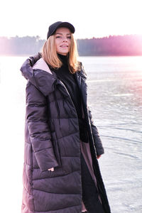 Young female smiling and looking at a camera in a snow landscape. happy hipster girl with hip hop 