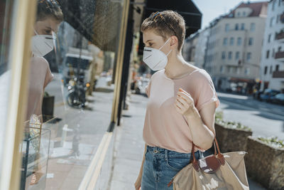 Midsection of woman standing on street in city