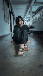 Portrait of woman sitting on floor at home