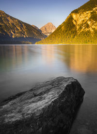 Scenic view of lake by mountains against sky