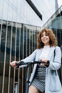 Portrait of smiling young woman holding umbrella