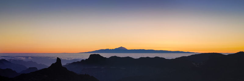 Scenic view of silhouette mountains against sky during sunset