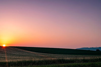 Scenic view of field against sky during sunset