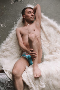 Full length of naked man lying down on fur
