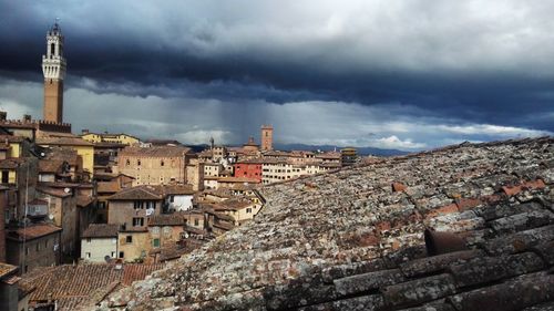 Aerial view of townscape against cloudy sky