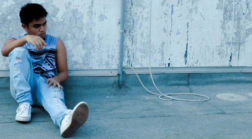 Man sitting against wall