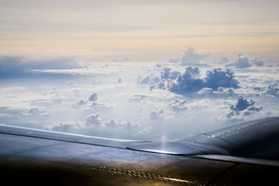 Airplane flying in sky at sunset