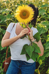 Low angle view of woman holding flowering plant