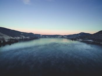 Scenic view of lake against clear sky during sunset