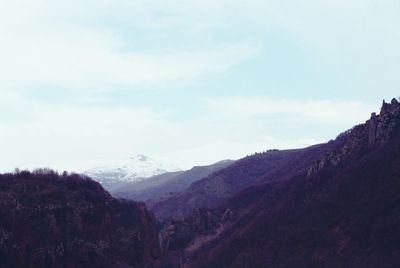Scenic view of mountains against cloudy sky