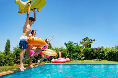 People in swimming pool against sky