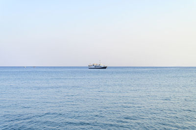 Sailboat sailing on sea against clear sky