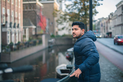 Portrait of young man standing in city